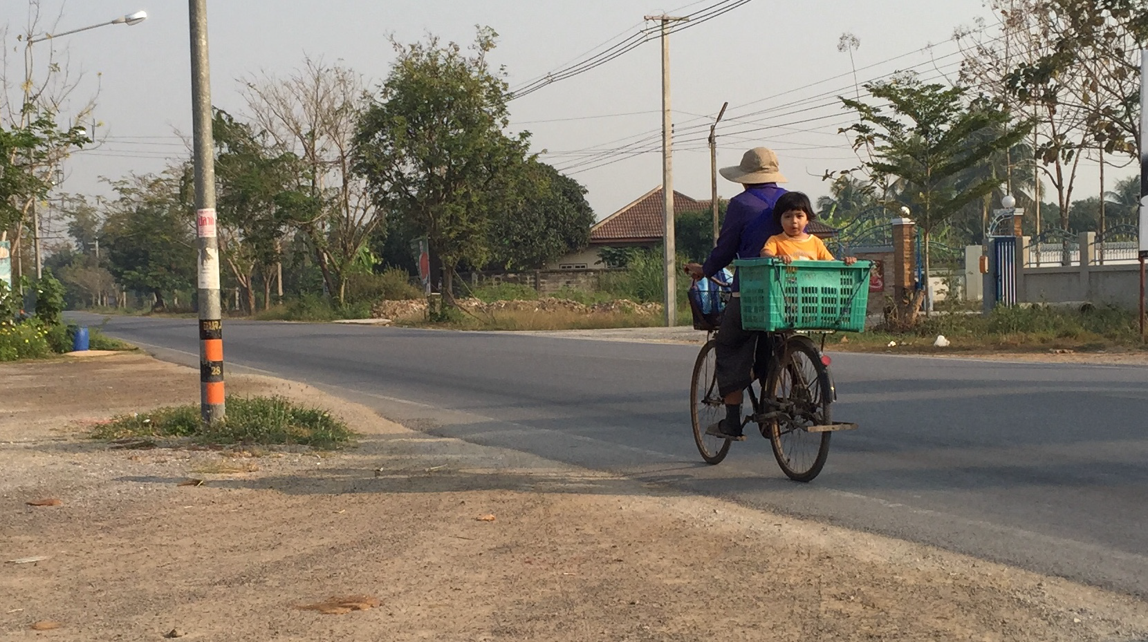 Young Thai child riding a small bike through a village